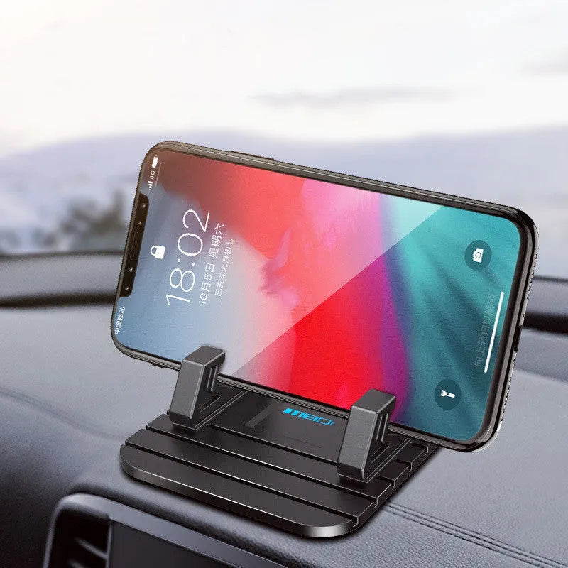 Car mobile phone bracket with anti-slip silicone mat on a centre console holding a smartphone