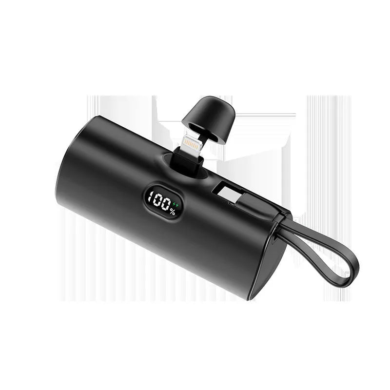 Compact capsule-shaped wireless power bank with digital display and integrated plug, shown in multiple colours.
