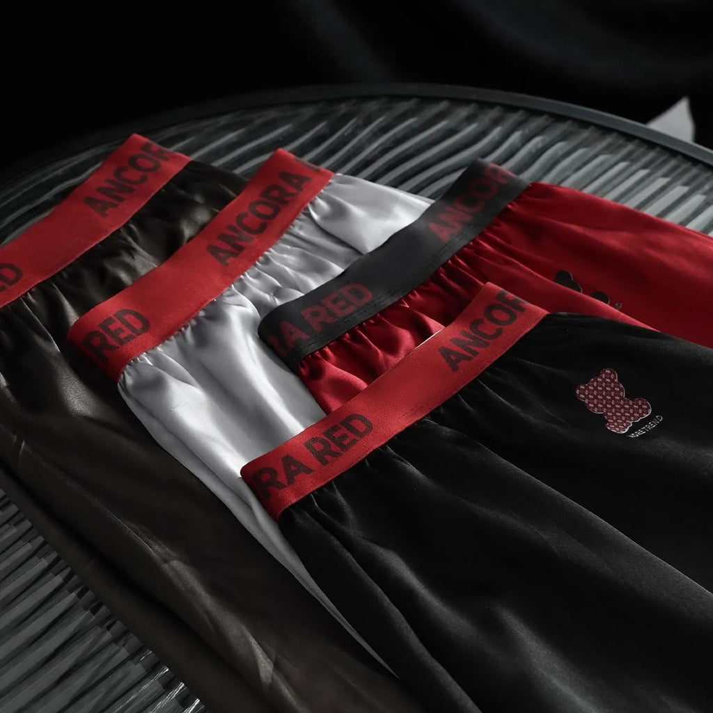 Solid colour men's boxer briefs on a mid waist, shown in black, red, blue, silver, purple, and brown.