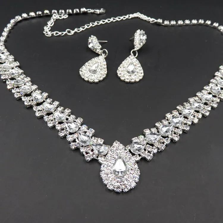 Gold bride wedding accessories set with drop earrings and necklace on white background