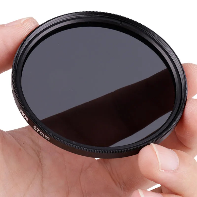 ND8 neutral density camera lens filter with silver aviation aluminium frame, shown next to a lens.