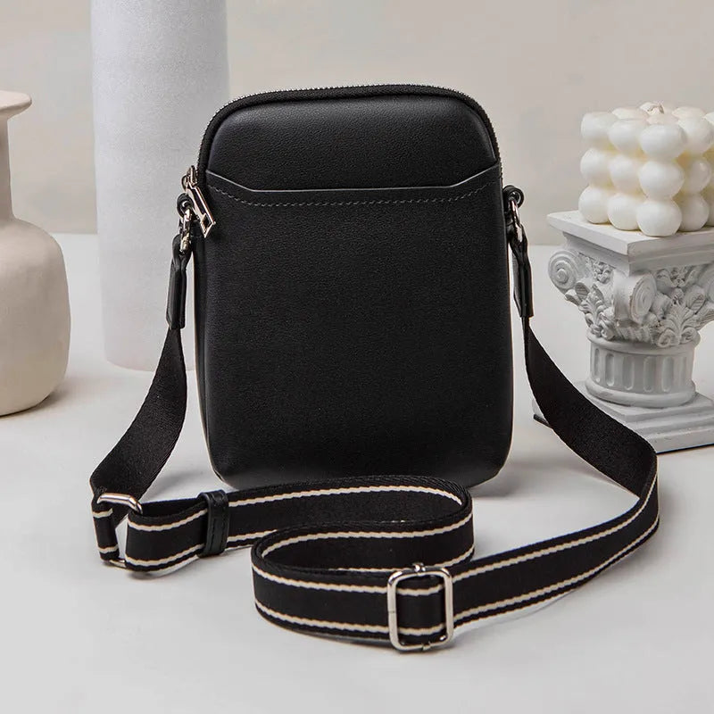 Solid colour small PU crossbody shoulder bag for mobile phones on a strap.