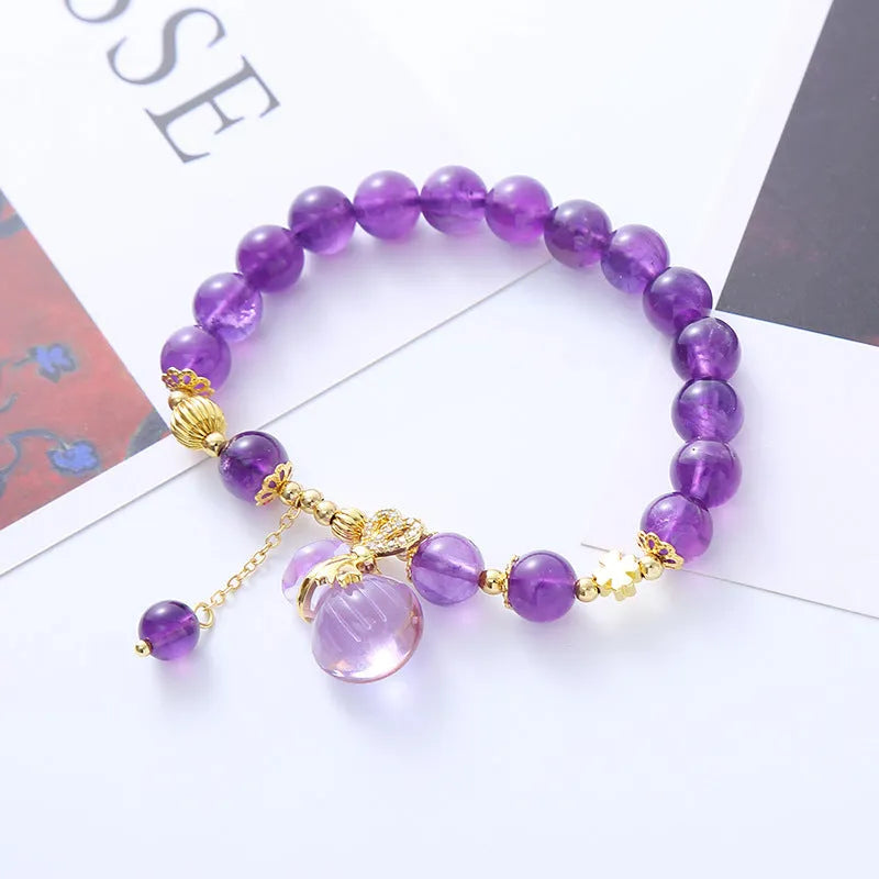Purple amethyst crystal bracelet with money bag pendant and geometric peace buckle on wrist