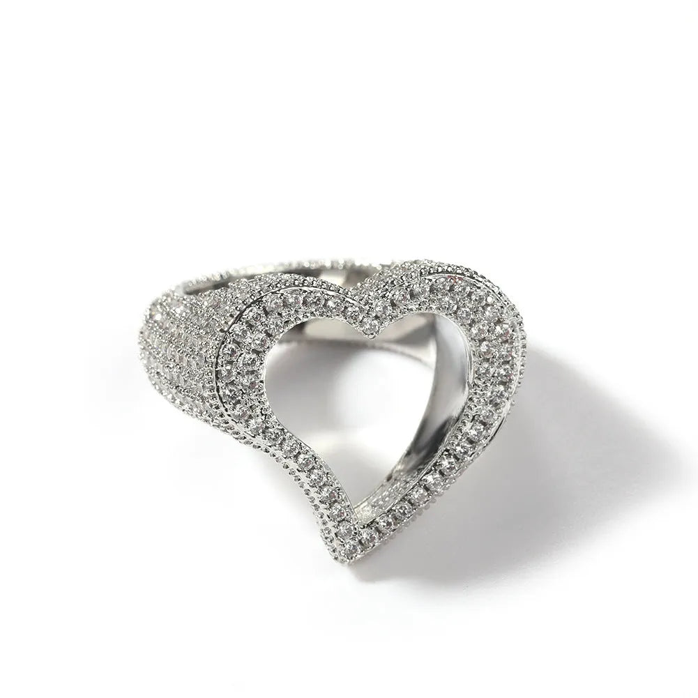 Gold copper ring with hollow heart cut-out and zircon stone on finger