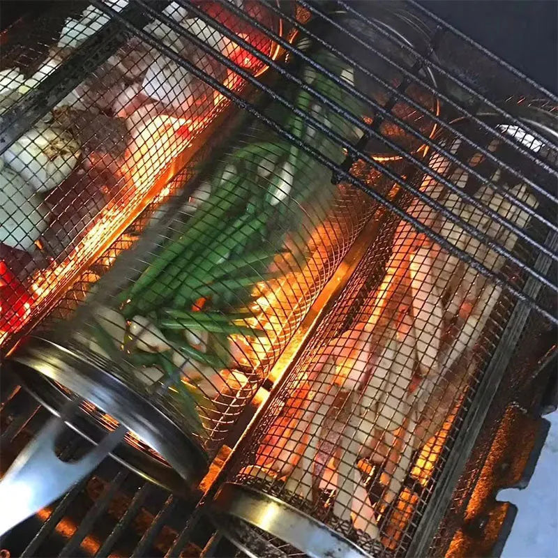 Stainless steel cylindrical rolling barbecue grilling basket with wire mesh on a grill.