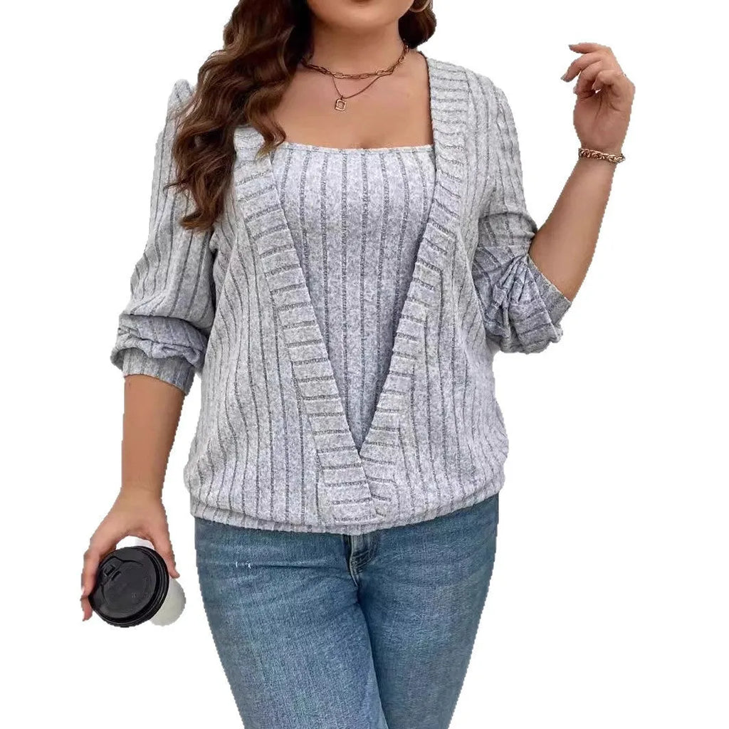 Solid colour ribbed knit V-neck false two-piece suit top with long sleeves on a hanger.