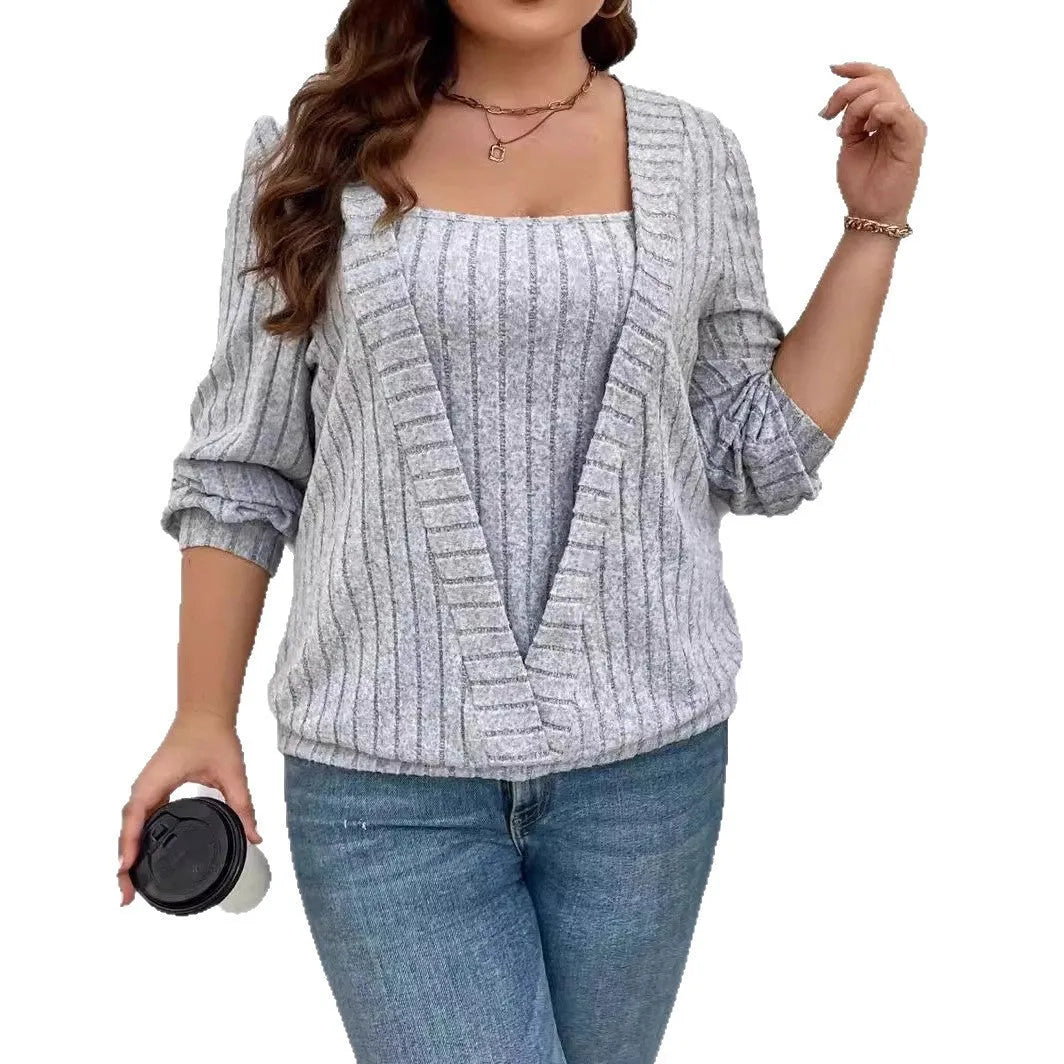 Solid colour ribbed knit V-neck false two-piece suit top with long sleeves on a hanger.