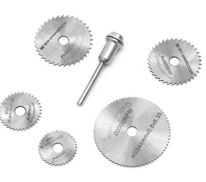 Six high-speed steel circular saw blades and a mandrel arranged on a surface.
