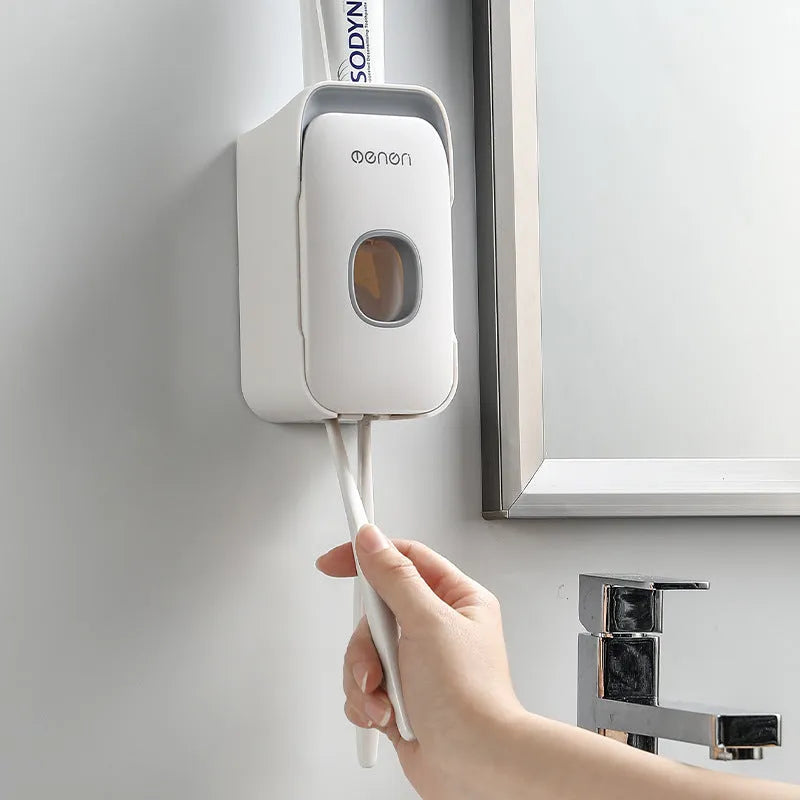 Blue, grey, and pink automatic toothpaste dispenser made of ABS plastic for wall mounting