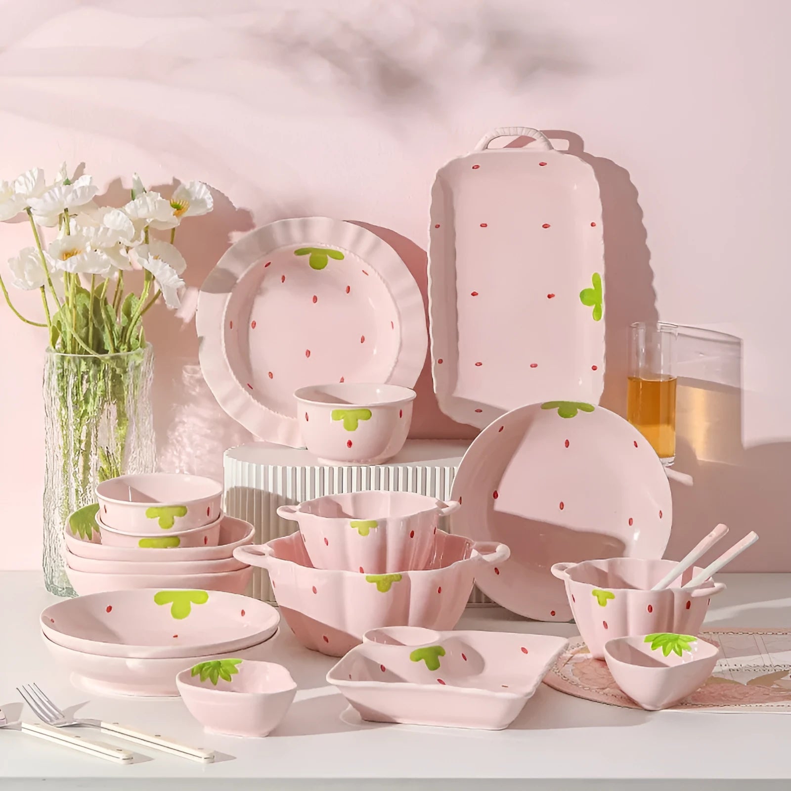 Porcelain dinnerware set with strawberry design showing bowls, plates, and a twist spoon.