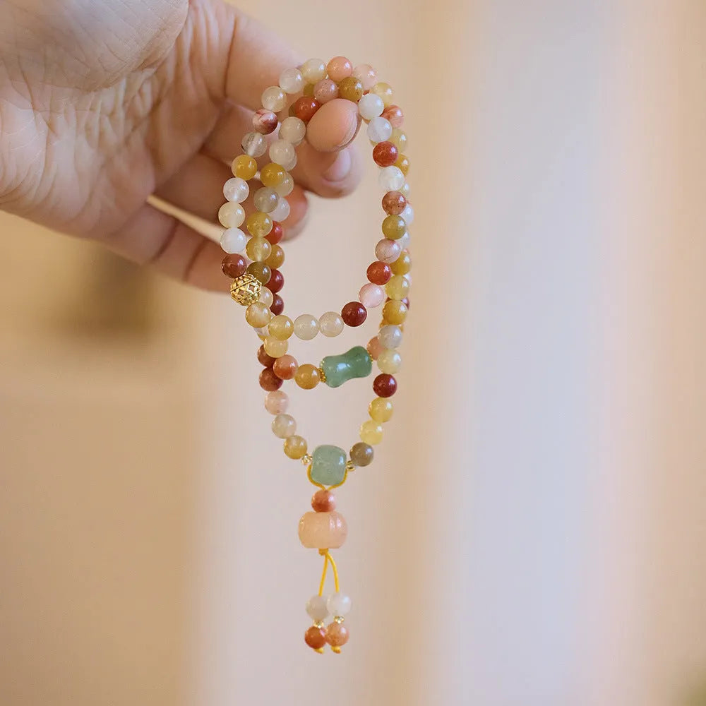 Women's Jinsi Jade bracelet with pumpkin tassel on a 14-16cm wrist.