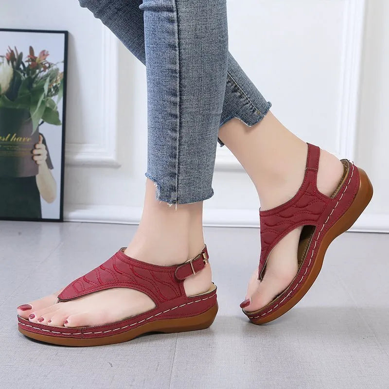 Women's wedge heel flip flop sandals with an adjustable back strap in solid black.