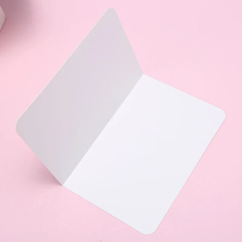 Pack of 100 folded kraft paper greeting cards in 10x15cm size, showing black, brown, and white colour options.