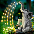 Grey resin elephant garden sculpture with built-in LED lighting on a patio.