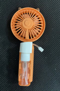 Compact plastic USB desk fan with a nozzle, shown in apricot colour on a desk.