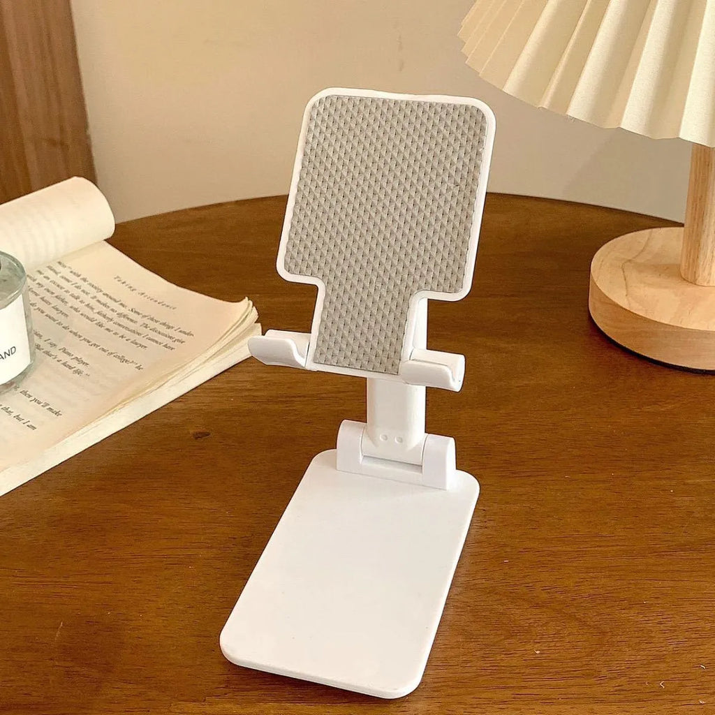 Folding plastic mobile phone stand in white, showing universal groove for hands-free viewing
