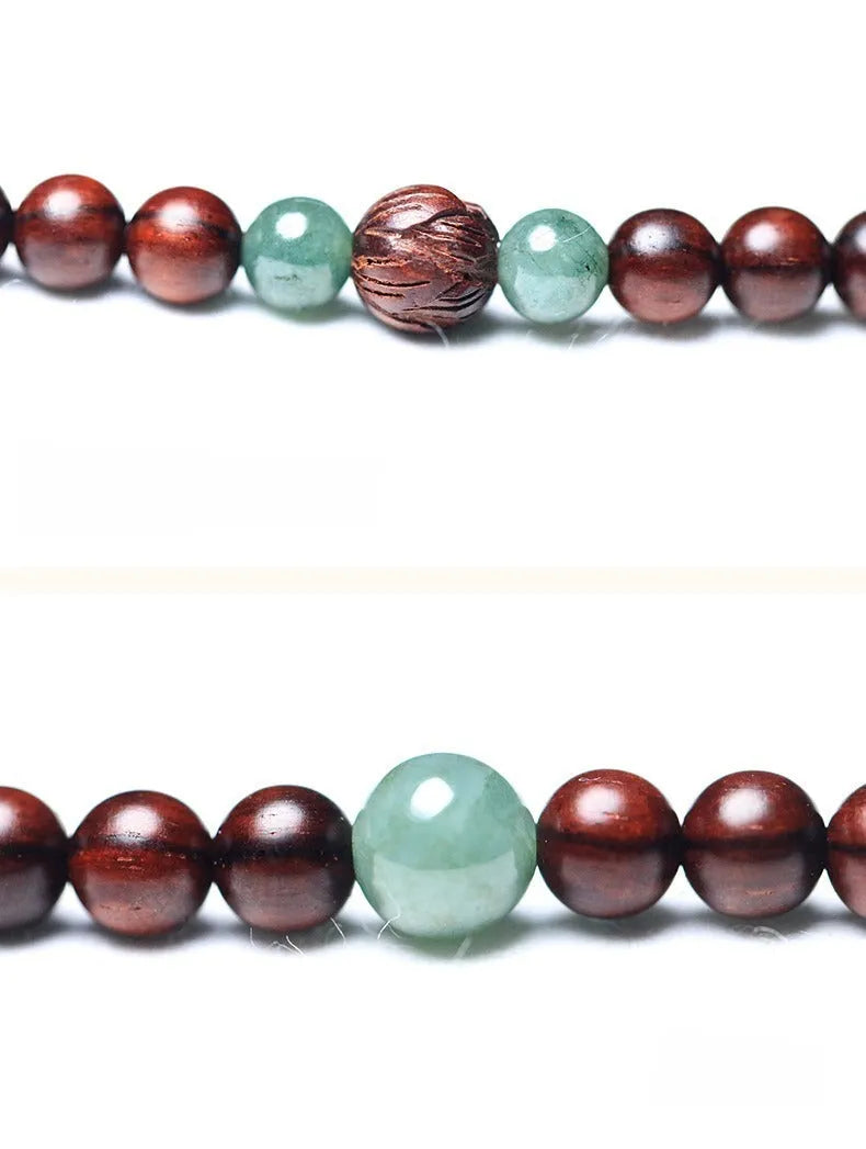 A wooden beaded bracelet with a carved green Hotian jade pendant on a natural background.