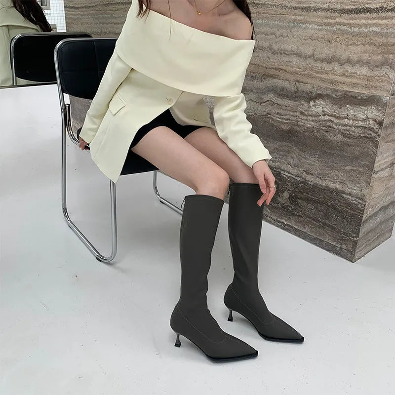 Women's black pointed toe stiletto boots with a back zipper, shown from the side.