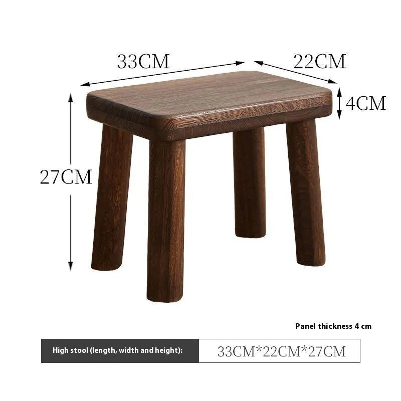 Distressed solid wood household stool for changing shoes in a living room setting.