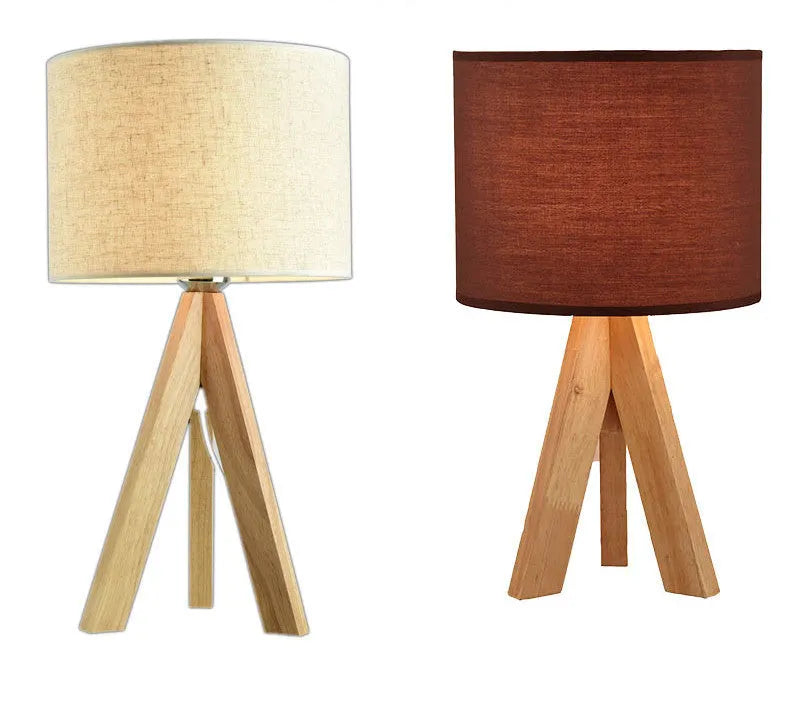 Solid wood LED table lamp with fabric shade in linen trumpet colour on wooden bedside table