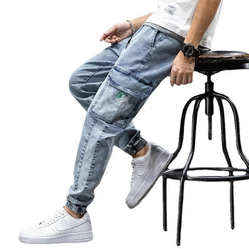 A pair of men's loose-fit cargo jeans in a blue colour, showing the straight leg and casual style.