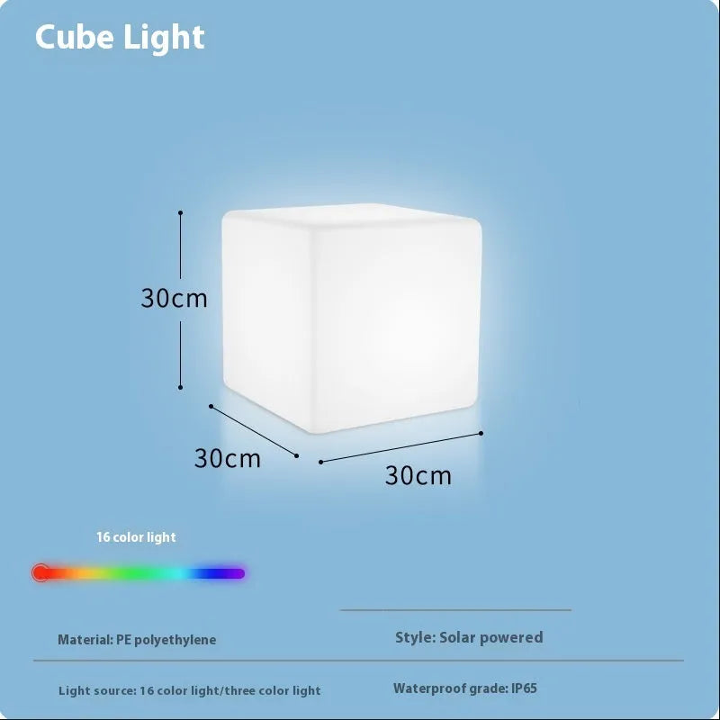 A white square cube LED stool light sitting on a patio, illustrating its modern design and outdoor use.