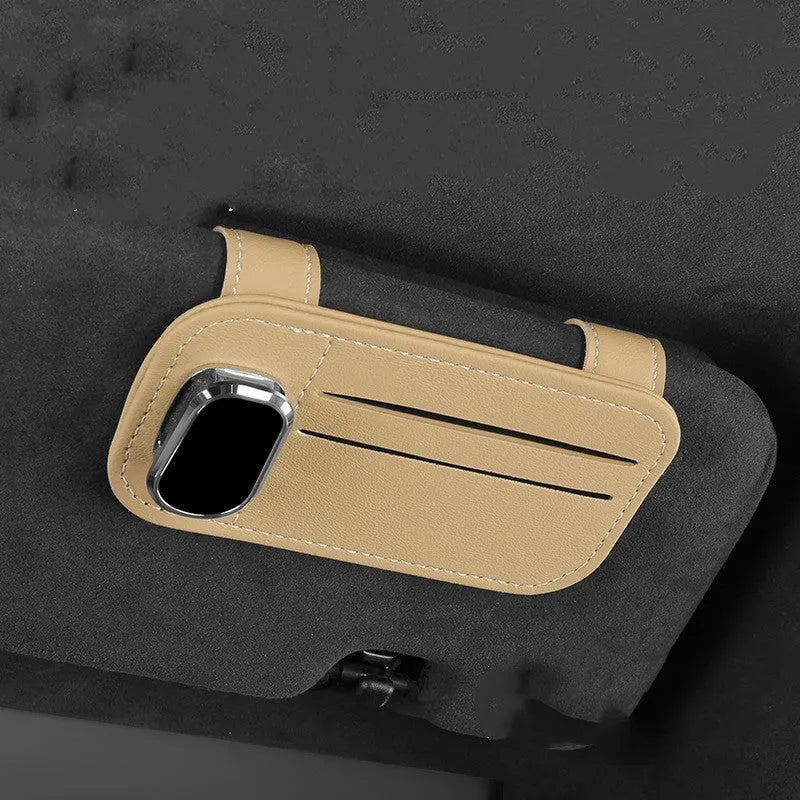 Beige cowhide automotive sun visor clip holding cards and sunglasses.