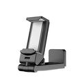 A black foldable rotating lazy phone holder gripping a mobile smartphone on a desk.