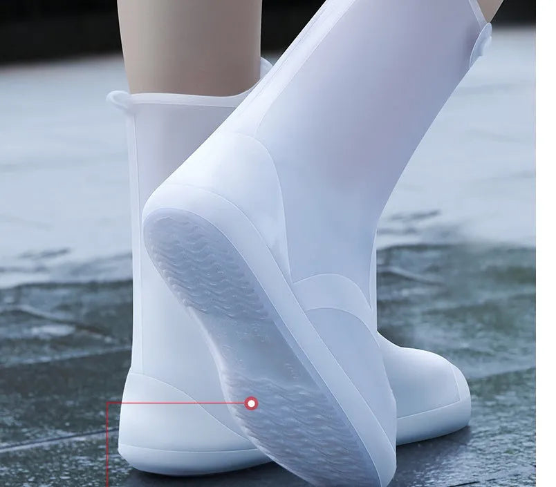 White high-top PVC reusable waterproof shoe covers for women on a wet surface.