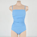 Blue sling style one-piece swimsuit with belly pleats and slim fit on model.