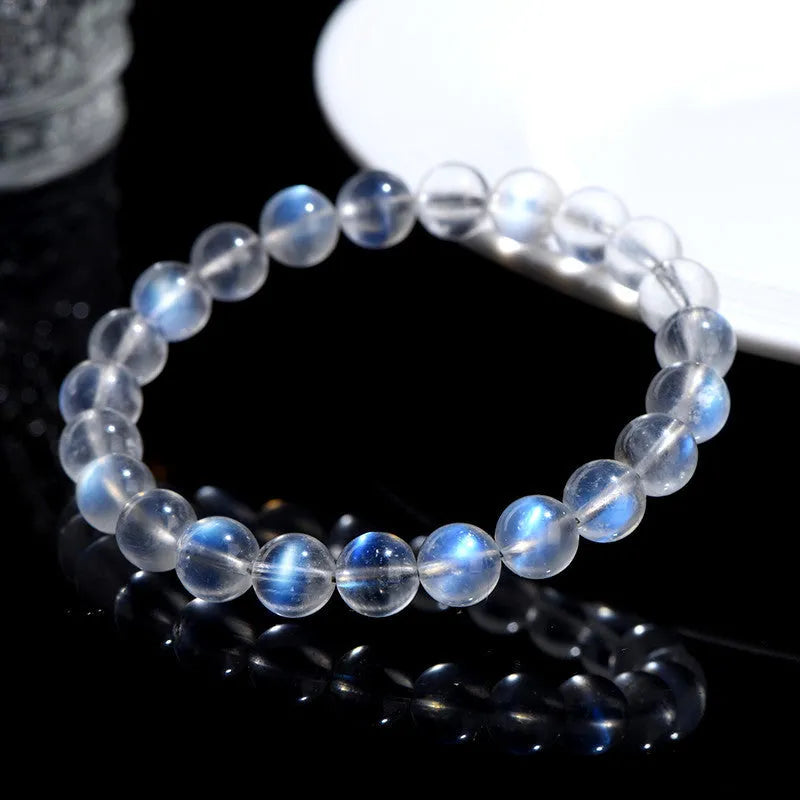 Natural blue moonlight crystal bracelet with cream body beads on a white background.
