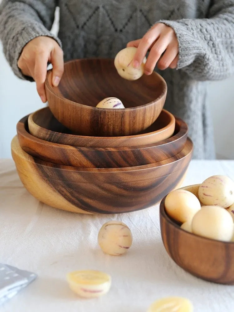 Handmade brown wooden bowl set showing multiple sizes from small to large on wooden table