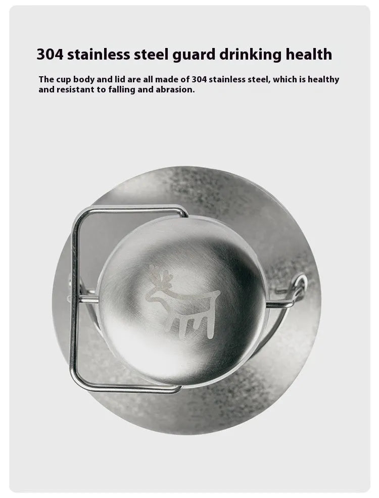 Large stainless steel outdoor thermal pot with a handle, shown in a natural setting.
