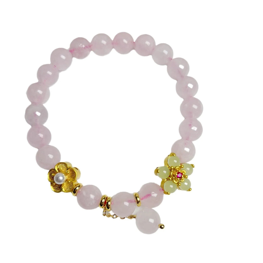 Close-up of a handmade pink crystal peach blossom bracelet on a wrist, showing adjustable closure.