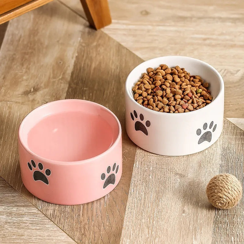 Ceramic cat food bowl with high foot base in a cat's paw print design