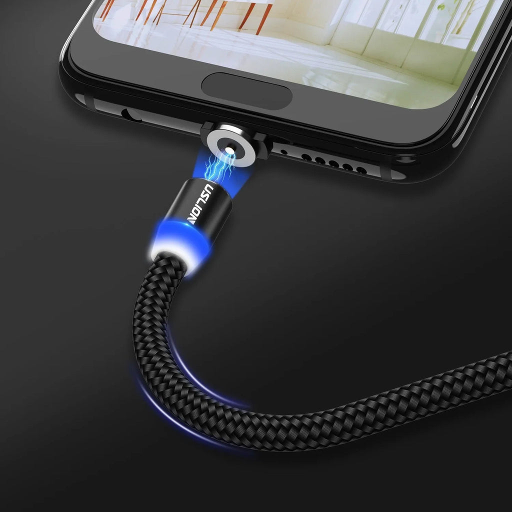USLION magnetic data cable with aluminium ends, shown in black, connecting to a smartphone charging port.
