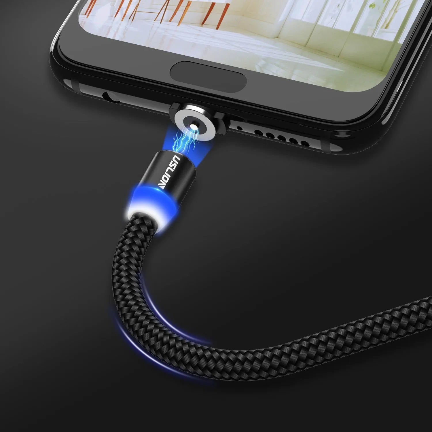 USLION magnetic data cable with aluminium ends, shown in black, connecting to a smartphone charging port.