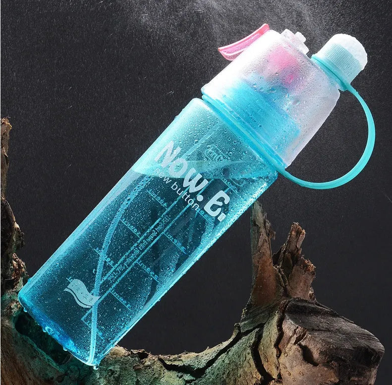 Green portable sports mist spray cup with transparent body, scale markings, and a black spray mouth cap.