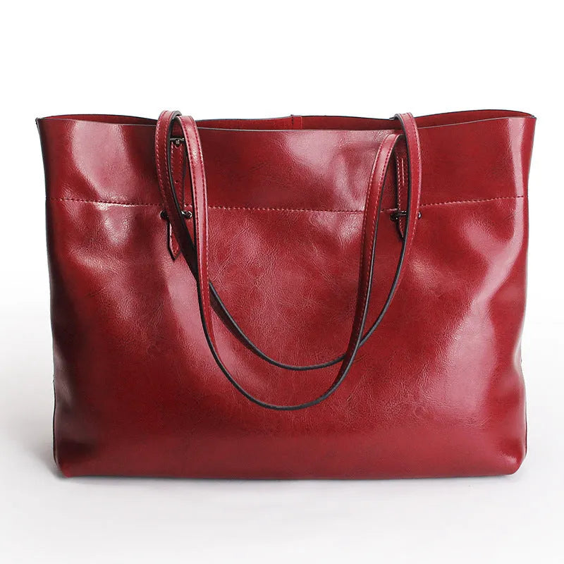 Brown waxed cowhide cross-body handbag with zip, showing two compartments and adjustable strap.