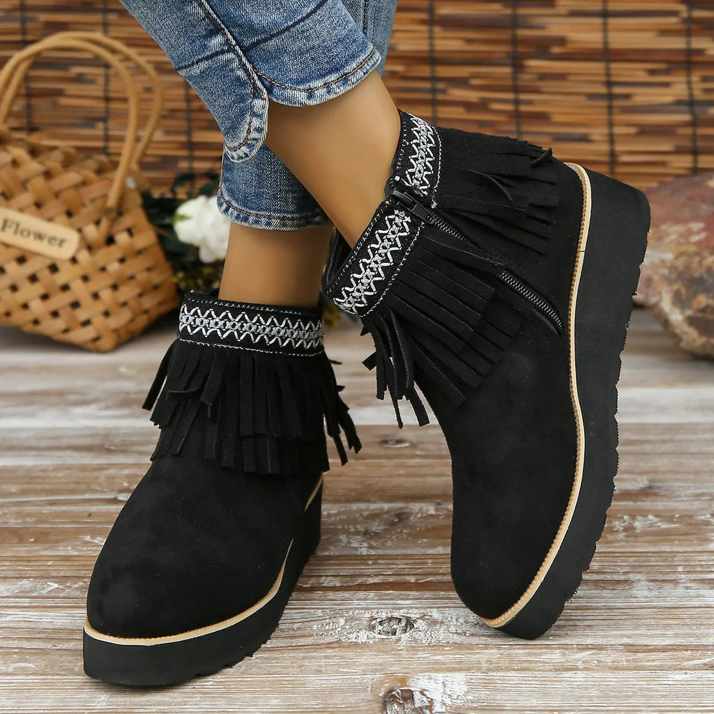 Women's dark brown suede ankle boots with a wedge heel, thick platform sole, tassel detail, and side zipper.