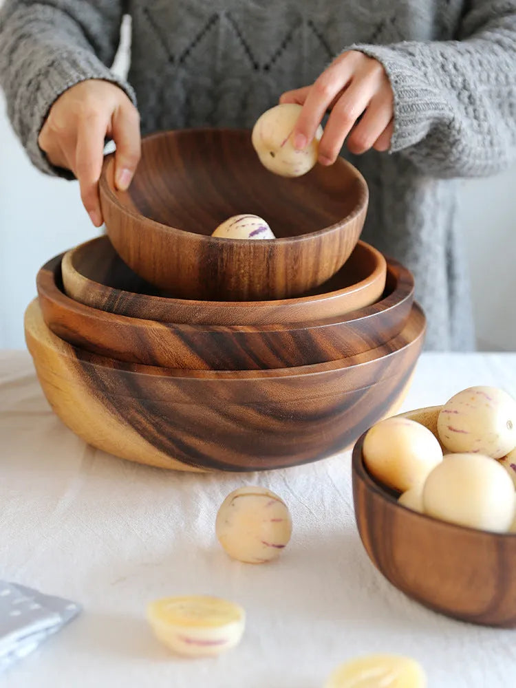 Handmade brown wooden bowl set showing multiple sizes from small to large on wooden table