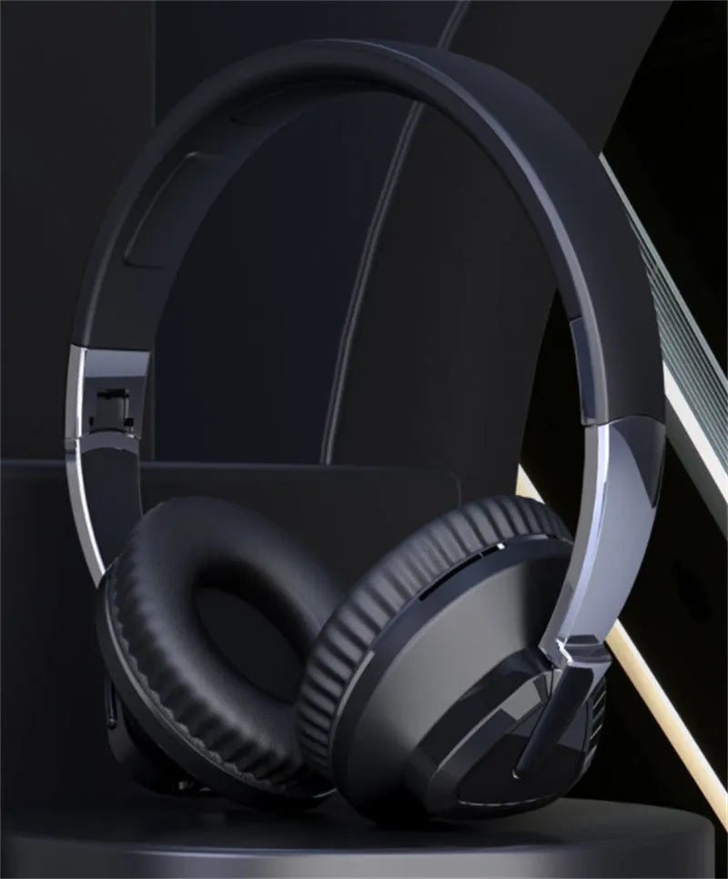 Black wireless over-ear Bluetooth headset with all-inclusive ear cups, showing AUX port and control buttons.