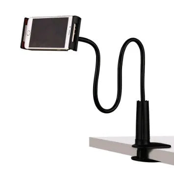 Black bedside phone holder with long arm extended, holding a mobile phone at an angle on a wooden table.
