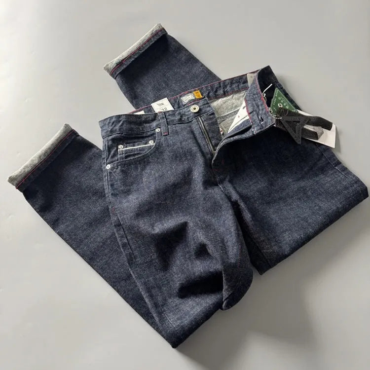 Man wearing blue straight leg denim jeans with a mid waist, showcasing the classic five-pocket retro design.