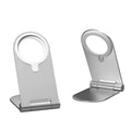 Silver aluminium alloy and plastic magnetic phone bracket for iPhone 12 on a desk.