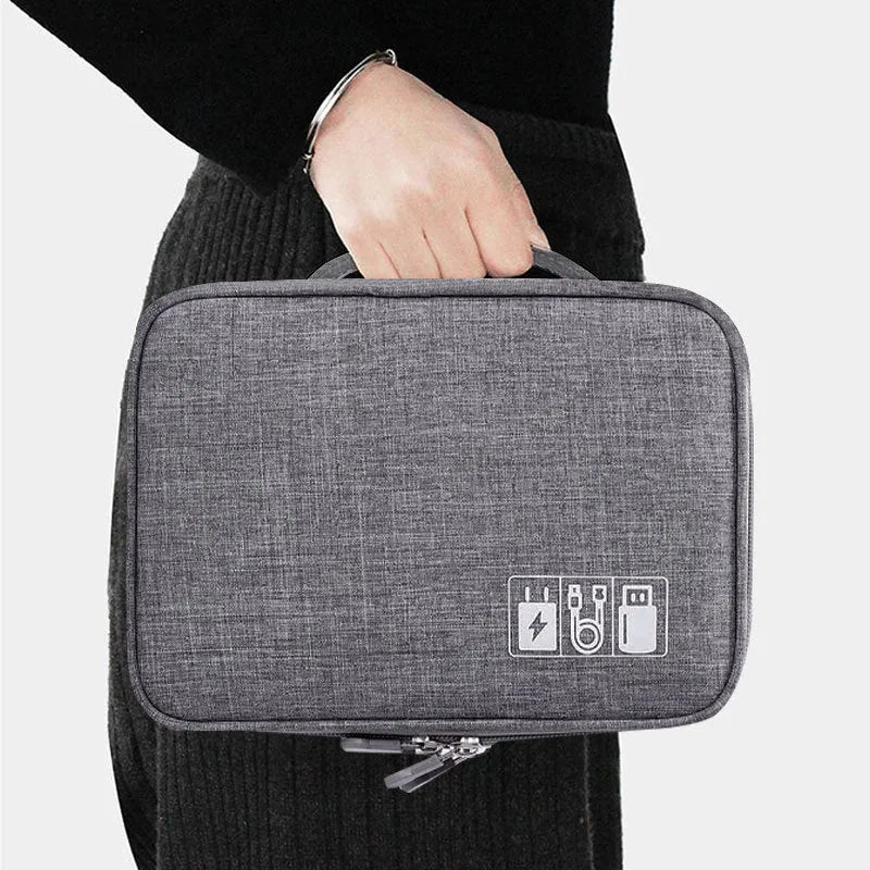 Grey waterproof electronics organiser bag with double-layer interior, handle, and zipper closure