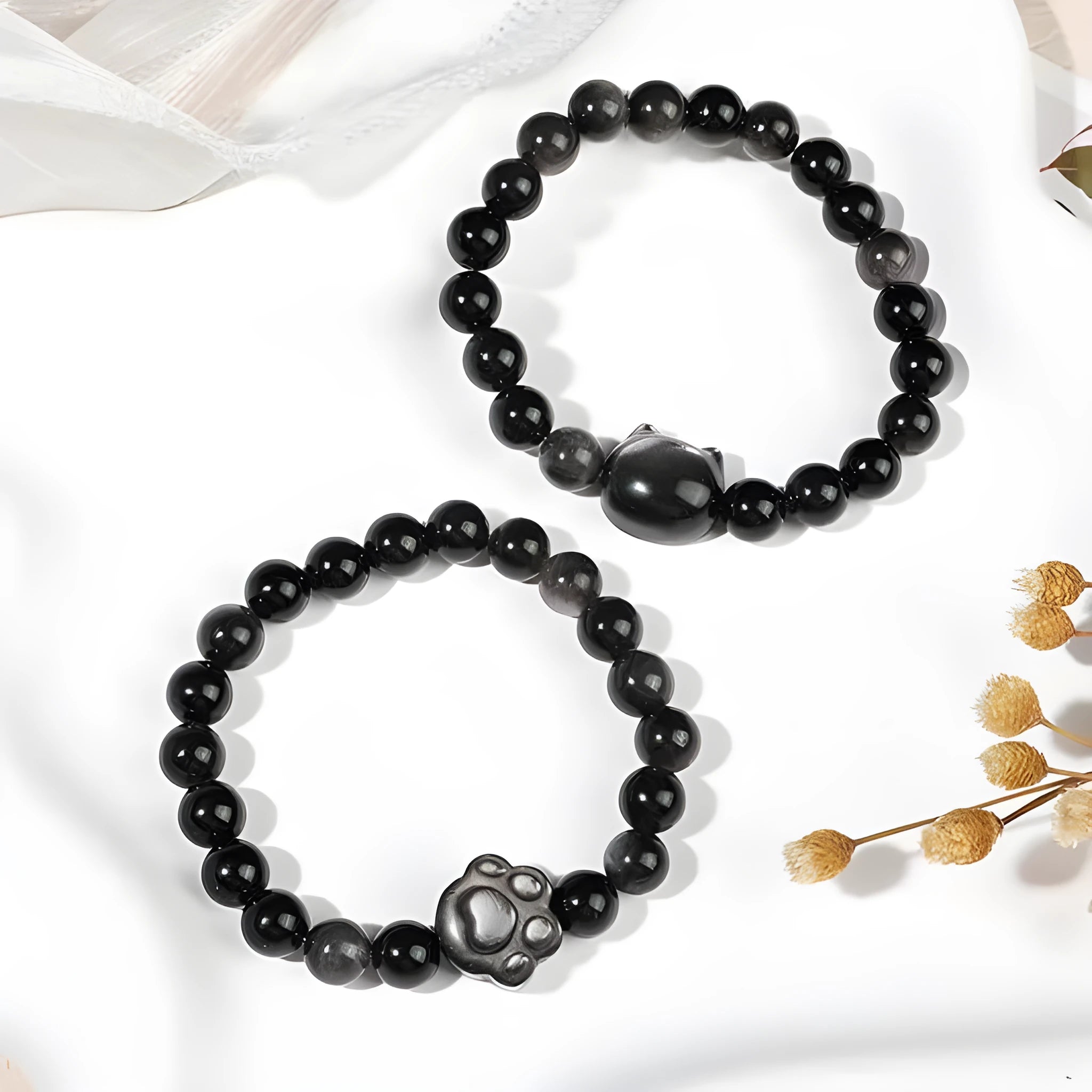 Handmade natural stone bead bracelet with silver cat pendant on neutral background