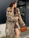 A model wearing a long faux fur coat with a fur collar and pockets.