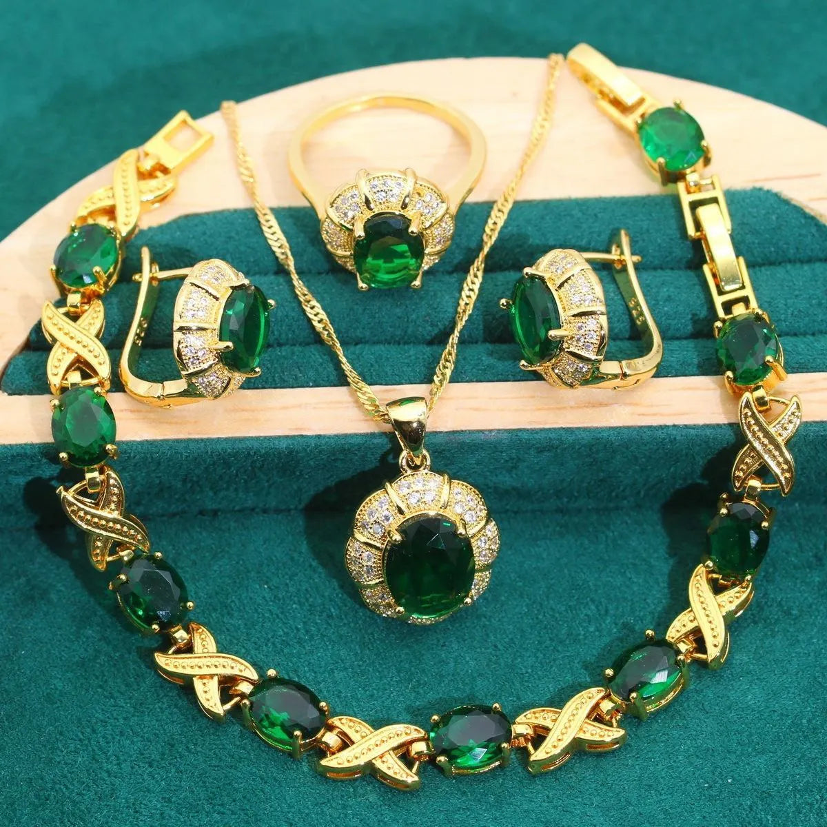 An 18k gold plated jewellery set with blue cubic zirconia stones, showing necklace, earrings, ring, and bracelet.