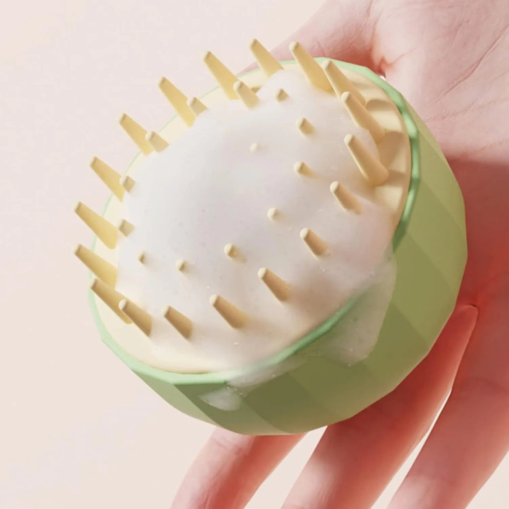 Green double-sided silicone pet bath massage brush with drain holes on a white background.